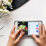 **A floral designer's Instagram feed. Focus on a bright, airy photo showcasing a modern floral arrangement incorporating Ikebana elements. Include hands working in the background, subtly showing the creative process. Add text overlay "Building Your Personal Brand."**